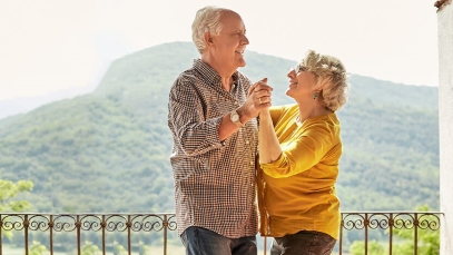 Mann und Frau tanzen zusammen auf Balkon im Hintergrund sind Berge